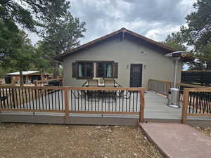 Back of property featuring a deck and outdoor dining space