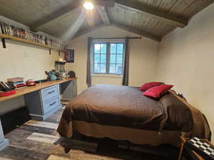 Bedroom featuring wood finished floors, built in study area, and wood ceiling