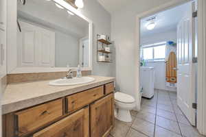 Bathroom featuring vanity, washer / dryer, and tile patterned floors