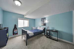 Bedroom featuring carpet flooring and a textured ceiling
