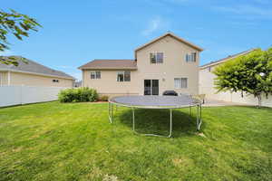 Rear view of house featuring a trampoline