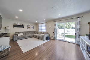 Living room featuring ornamental molding, wood finished floors, and recessed lighting