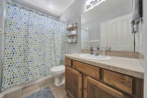 Bathroom with tile patterned flooring, vanity, a shower with shower curtain, and a textured ceiling