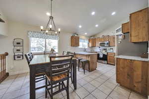 Dining area featuring a chandelier, light tile patterned flooring, recessed lighting, and vaulted ceiling