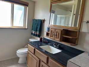Bathroom featuring vanity, a shower with shower door, and tile patterned floors