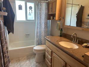 Full bathroom featuring vanity, shower / tub combo, and marble finish flooring