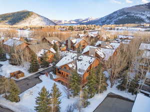Snowy aerial view featuring a mountain view and a residential view