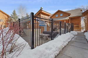 Snow covered house with a gate and a shingled roof