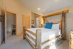 Carpeted bedroom with baseboards and lofted ceiling