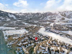 Snowy aerial view featuring a mountain view and a residential view