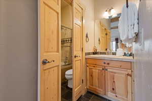 Bathroom featuring vanity, bathing tub / shower combination, and a textured wall
