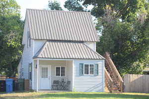 View of front of house featuring stairway and a metal roof