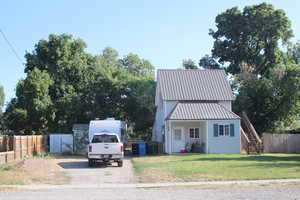 View of front facade featuring stairway and a metal roof