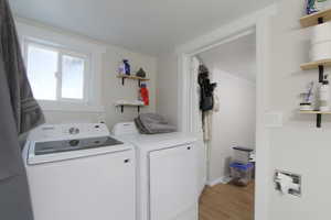 Laundry area featuring washer and dryer and light wood-type flooring