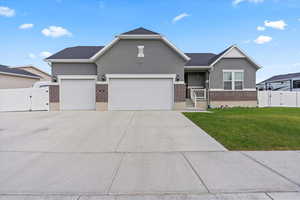 Ranch-style home featuring a gate, stucco siding, brick siding, concrete driveway, and three car garage