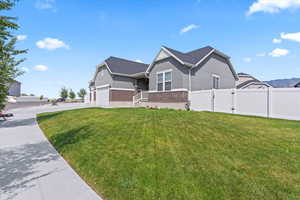 View of front of home with brick siding, a gate, driveway, stucco siding, and a garage