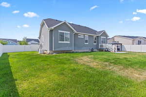 Back of property featuring a generator, a gazebo, a fenced backyard, stucco siding, and a shingled roof