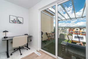 Office area featuring wood finished floors, plenty of natural light, and a residential view
