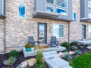 Doorway to property featuring stone siding and covered porch
