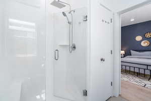 Full bath with a stall shower and wood finished floors
