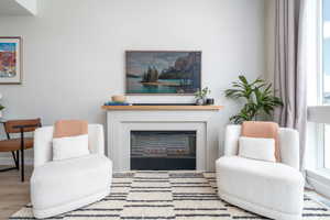 Living room with wood finished floors and a glass covered fireplace