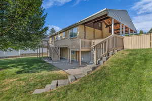 Back of property with stairway, a wooden deck, and a patio area