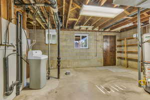 Unfinished basement with a water softener and gas water heater