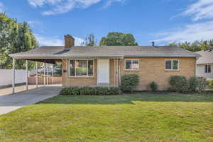 View of front of home featuring brick siding, a carport, concrete driveway, and a shingled roof