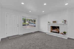 Unfurnished living room with carpet flooring, recessed lighting, and a fireplace