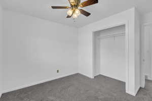 Unfurnished bedroom with carpet flooring, a closet, and a ceiling fan