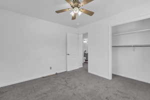 Unfurnished bedroom with carpet flooring, a closet, and ceiling fan
