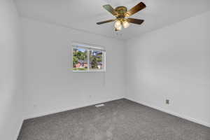 Carpeted empty room with baseboards and ceiling fan