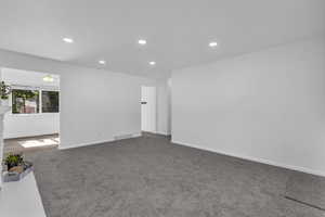 Empty room featuring recessed lighting and dark colored carpet