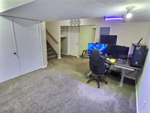 Office area featuring carpet floors and a textured ceiling