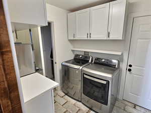 Laundry room with cabinet space and washer and dryer