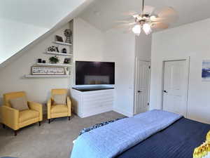 Bedroom featuring carpet, ceiling fan, and vaulted ceiling