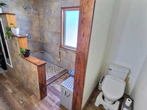 Full bathroom featuring tiled shower and wood finished floors