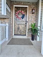 View of exterior entry featuring brick siding