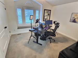 Home office featuring carpet floors and vaulted ceiling