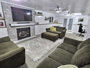Living area featuring ceiling fan, a fireplace, an office area, and french doors