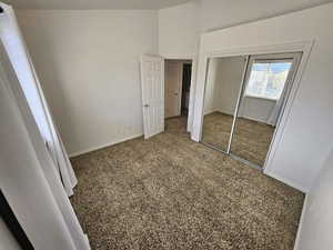 Unfurnished bedroom with a closet and dark colored carpet