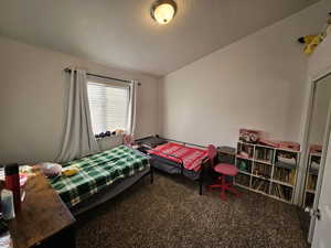 Bedroom with a textured ceiling and carpet flooring