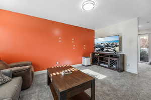 Carpeted living area featuring baseboards