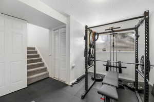 Workout area featuring baseboards and a textured ceiling