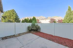 Fenced backyard featuring a patio and a mountain view