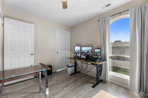 Home office featuring light wood-style floors and a ceiling fan