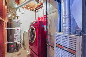 Laundry room featuring washer / clothes dryer, strapped water heater, and heating unit