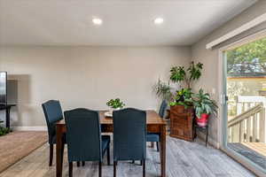 Dining area with light wood-style flooring and recessed lighting