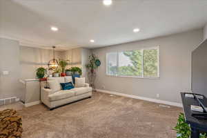 Carpeted living area featuring a chandelier and recessed lighting