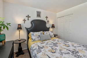 Carpeted bedroom featuring a closet and baseboards